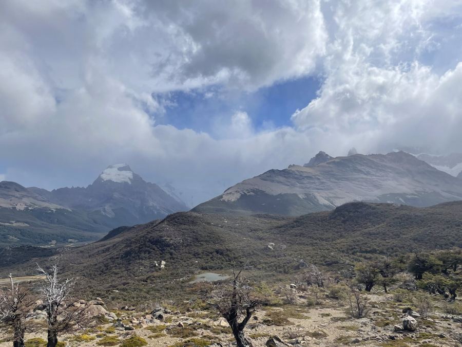 Cloud swirling around high peaks above a dry plateau of low beech trees
